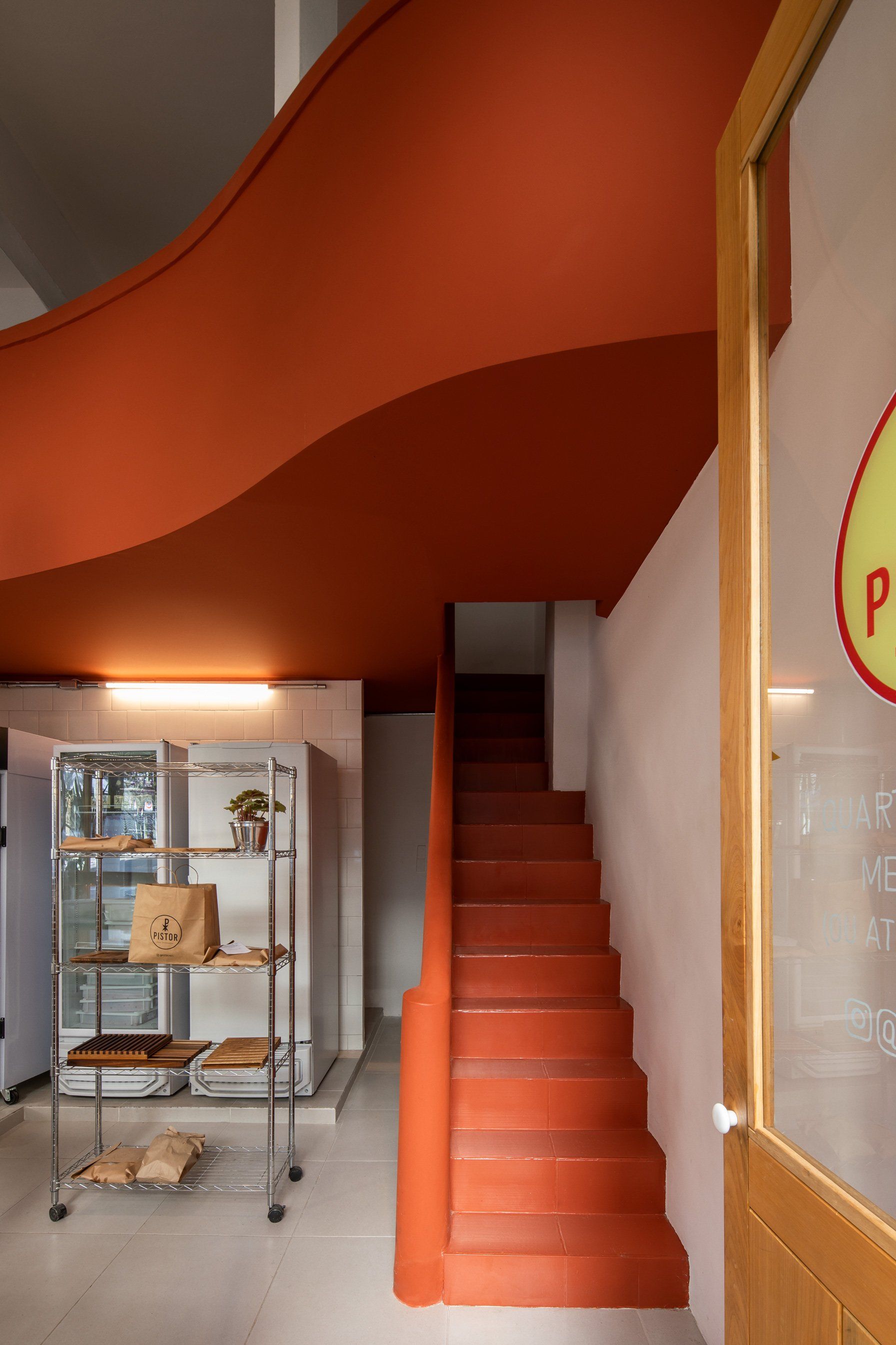 Uma escada vermelha que leva ao segundo andar de um prédio.