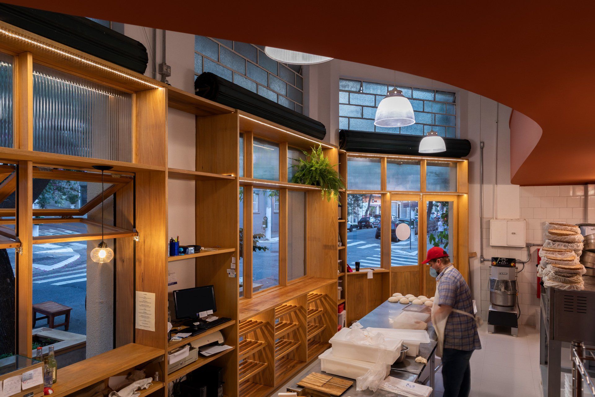 Uma mulher está parada no balcão de uma padaria.