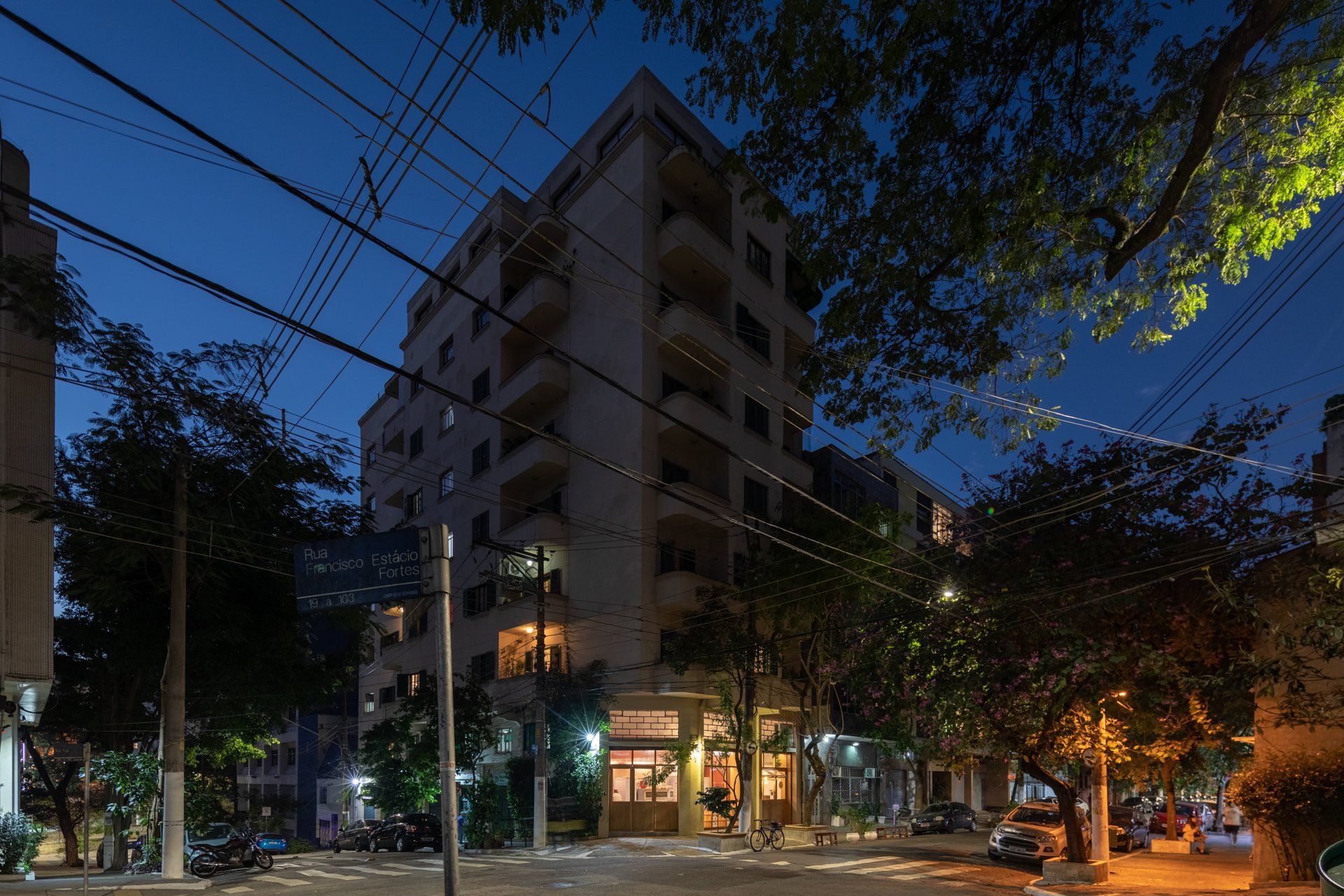 Um grande edifício com muitas janelas fica iluminado à noite.