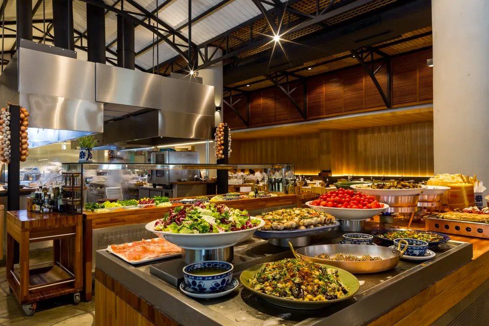 Uma mesa de bufê em um restaurante repleto de muita comida.