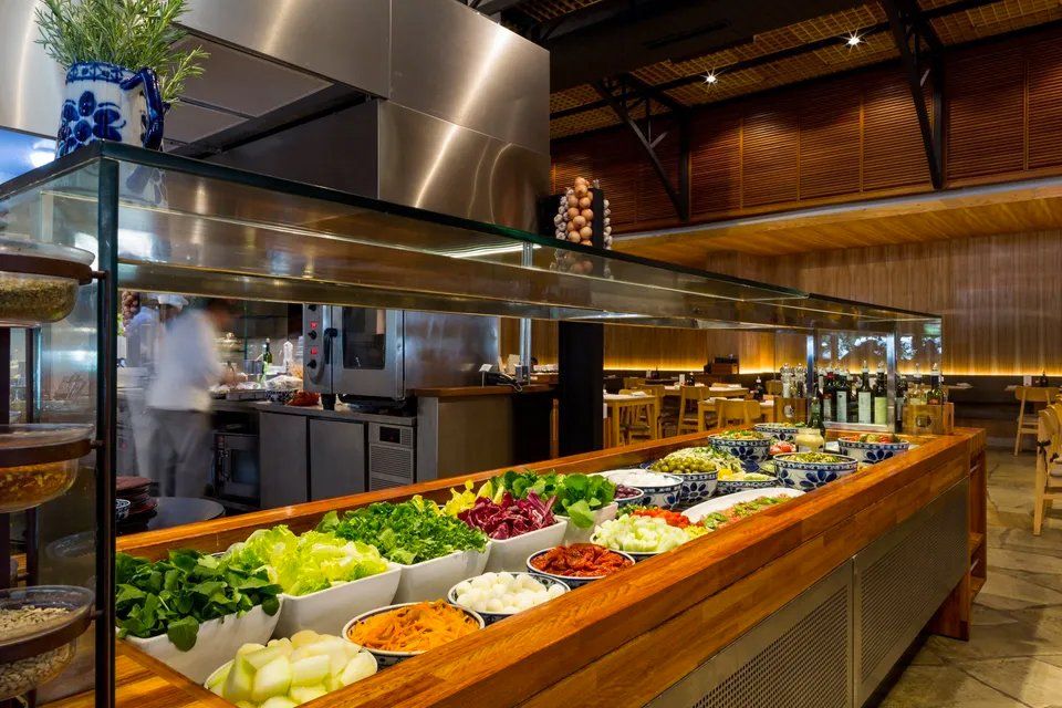 Uma fila de buffet em um restaurante com muitos vegetais.