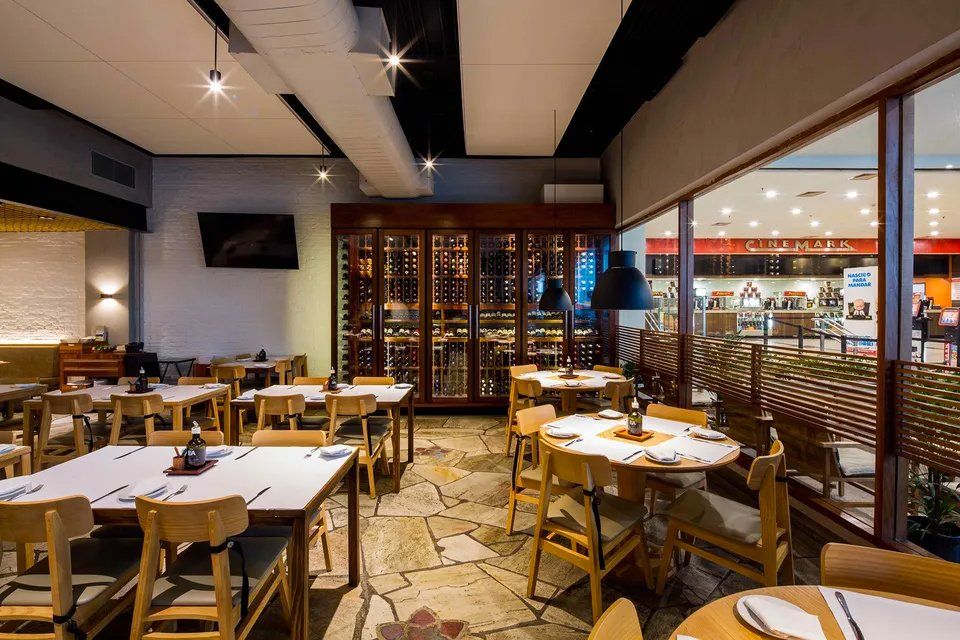 Um restaurante com mesas e cadeiras e uma adega
