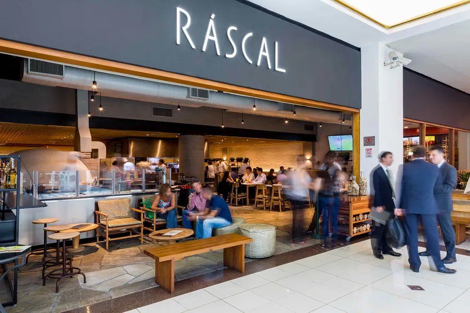 Um grupo de pessoas do lado de fora de um restaurante chamado malandro.