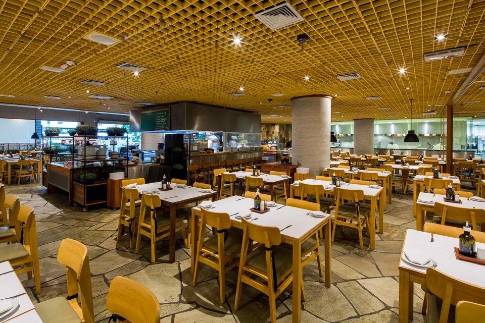 Um restaurante com mesas e cadeiras e buffet