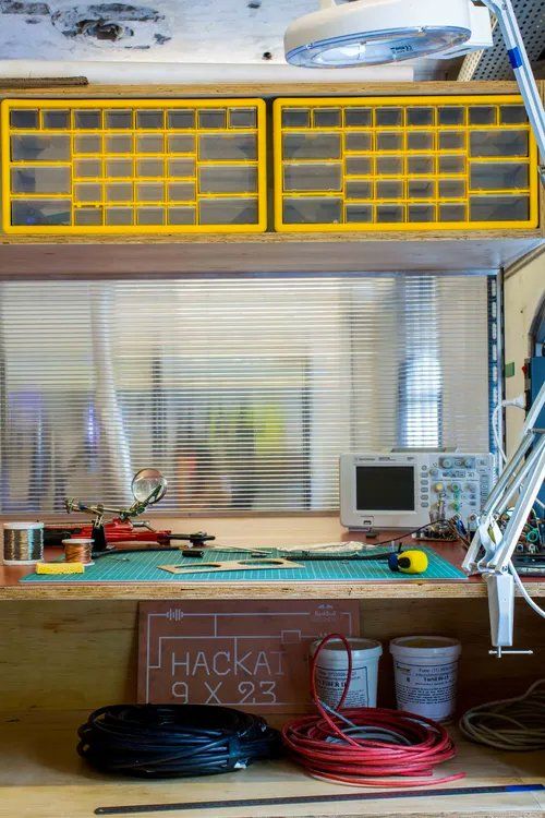 Uma bancada com muitas ferramentas e um computador.