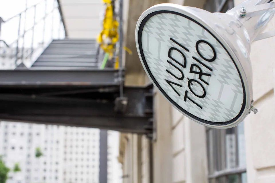 Uma placa na lateral de um prédio que diz Audi Torio