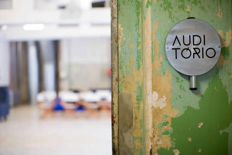 Uma placa em uma parede verde que diz Audi Torio