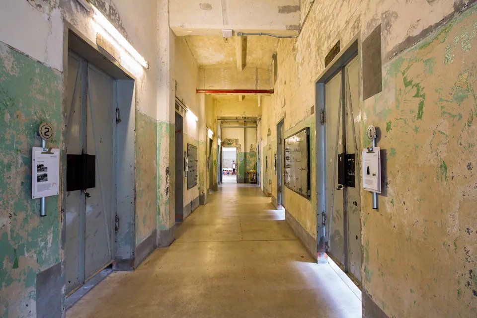 Um longo corredor com muitas portas em um prédio.