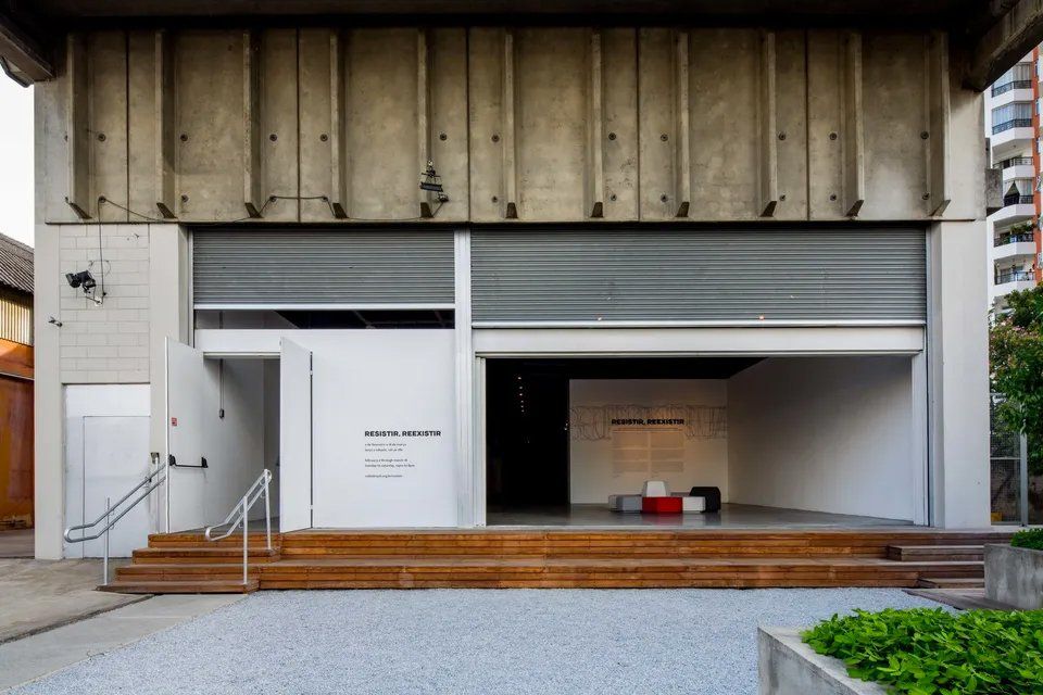 Um grande edifício de concreto com deck de madeira e escadas que levam até ele.