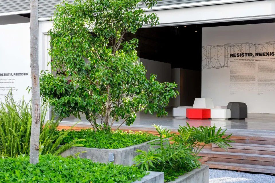 Um prédio branco com uma árvore na frente