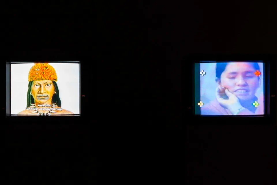 Um homem e uma mulher estão sentados um ao lado do outro na tela de uma televisão.