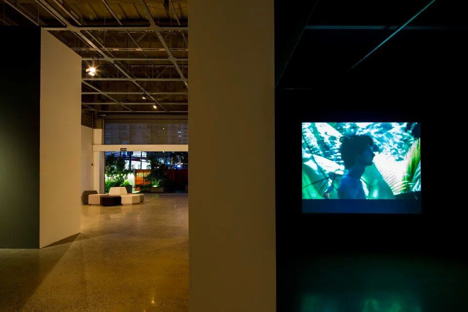 Uma pintura de um homem está na parede de um quarto escuro.