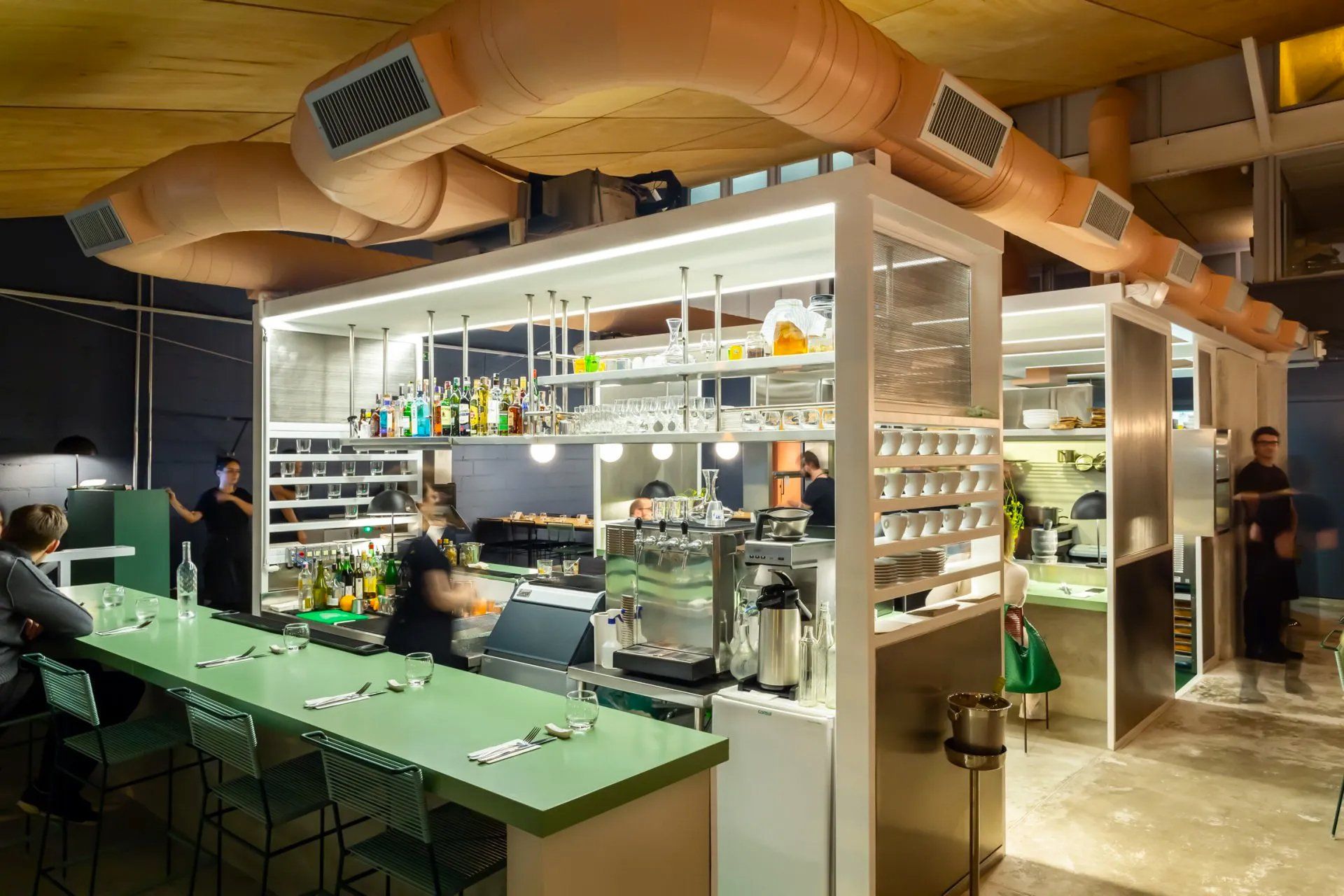 Um grupo de pessoas está sentado em uma longa mesa em um restaurante.