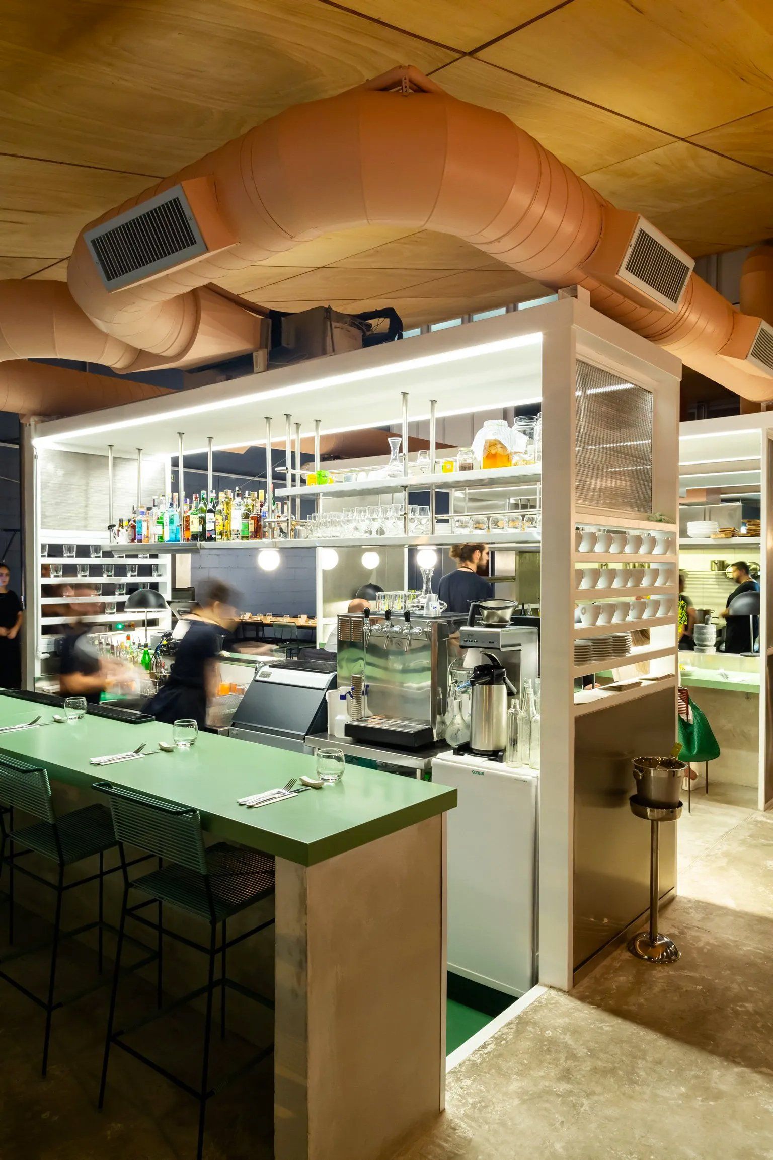 Um restaurante com balcão comprido e bancos e um bar.