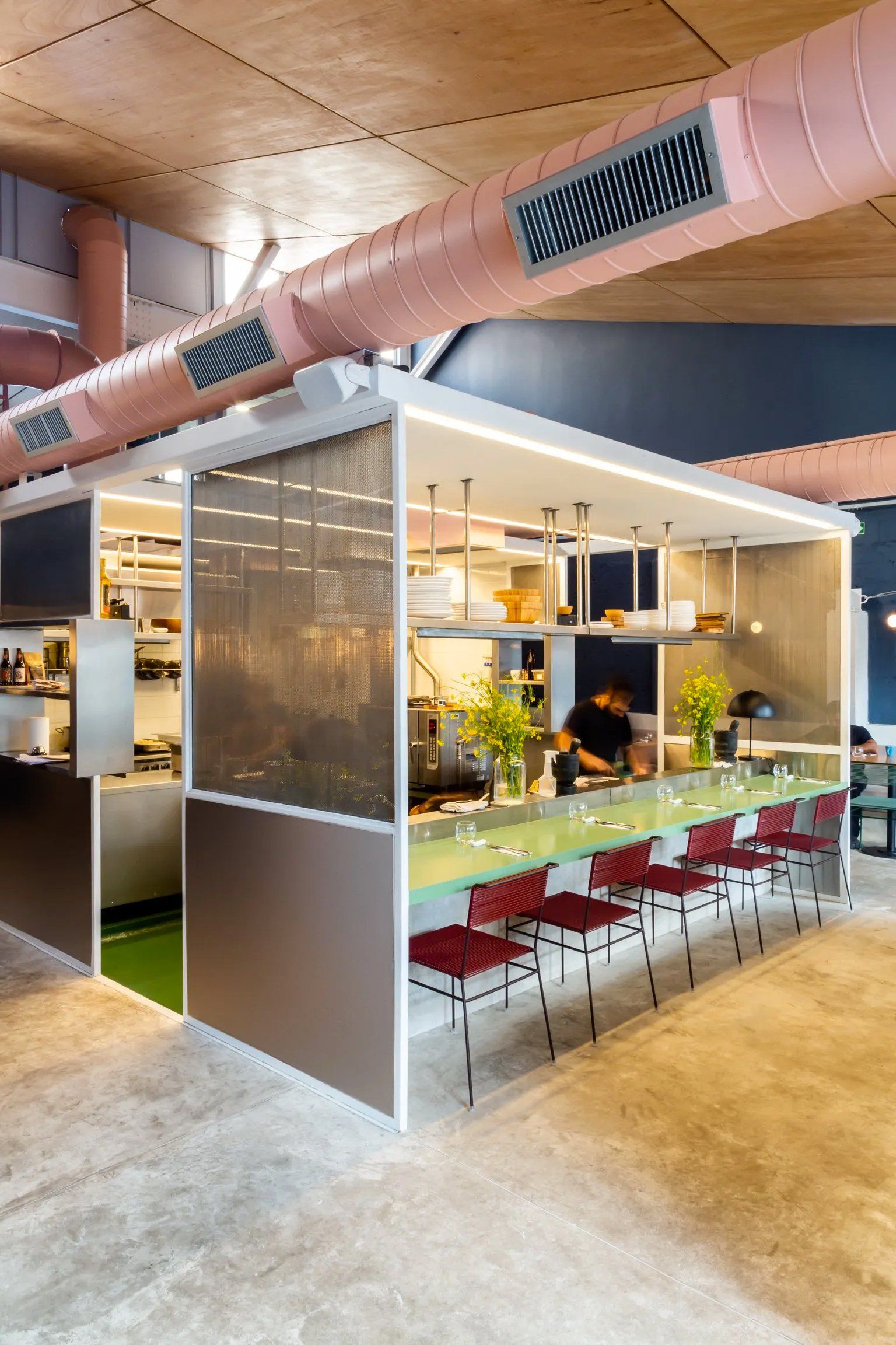 Um restaurante com uma longa mesa e cadeiras.