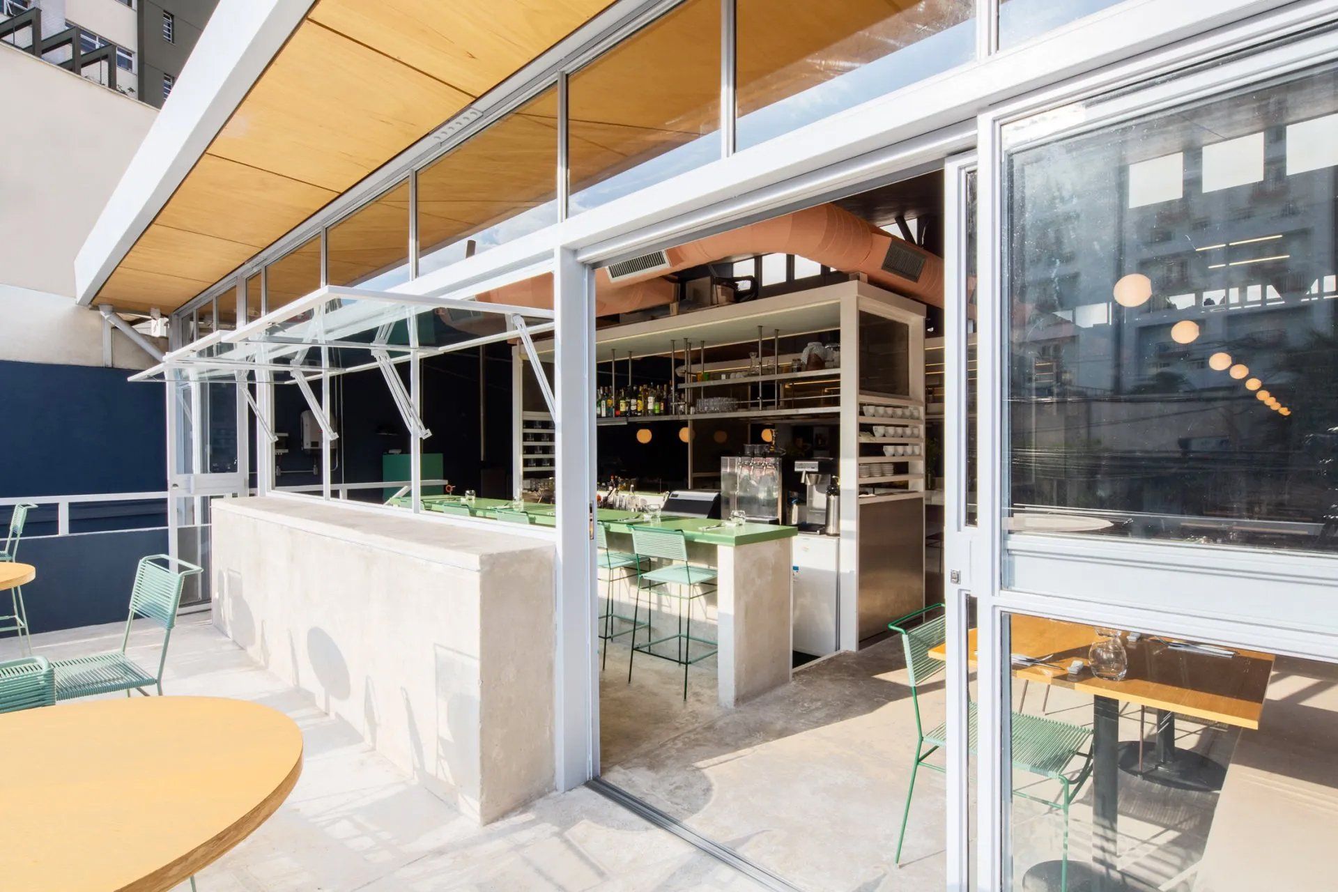 Um restaurante com mesas e cadeiras e portas de correr de vidro.