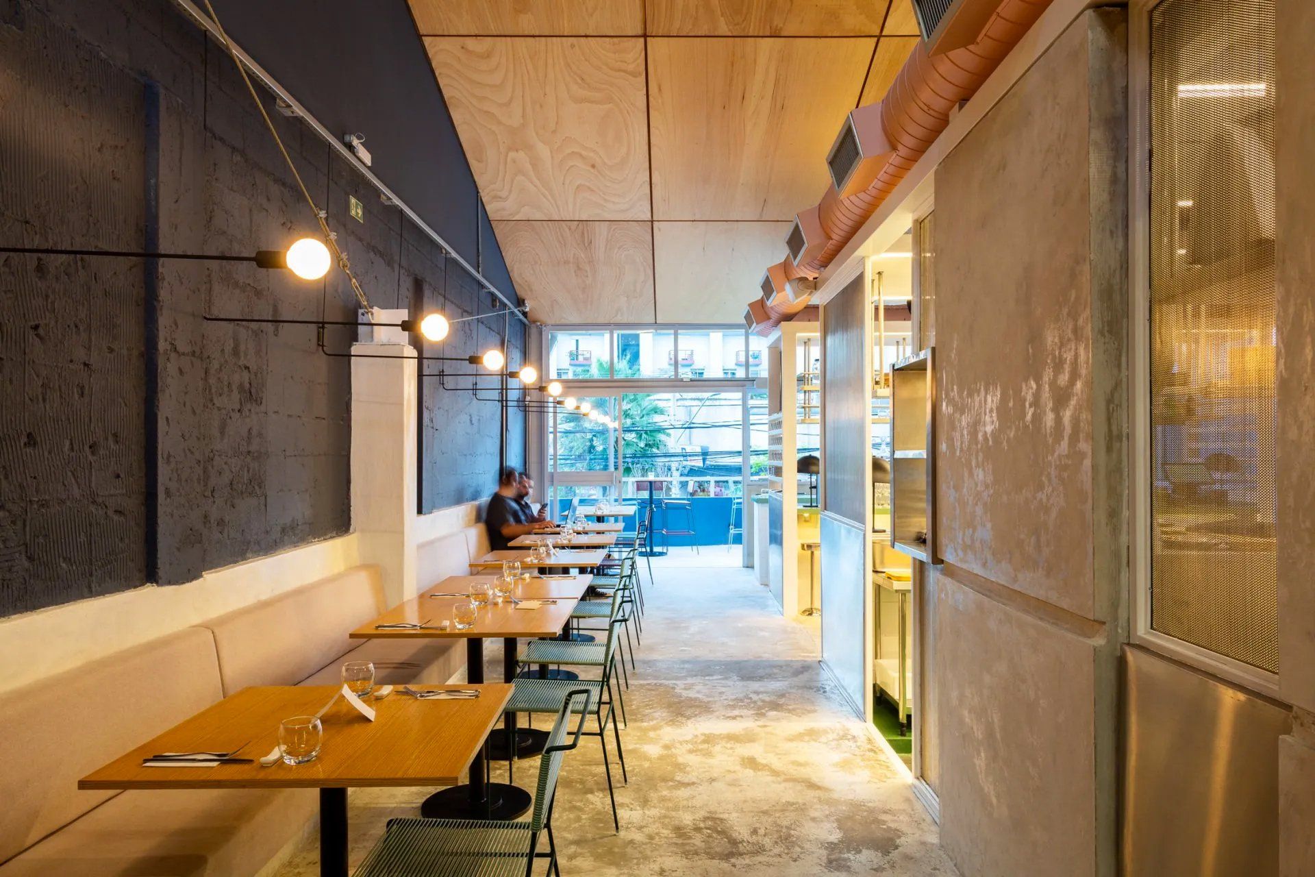 Um longo corredor com mesas e cadeiras em um restaurante.