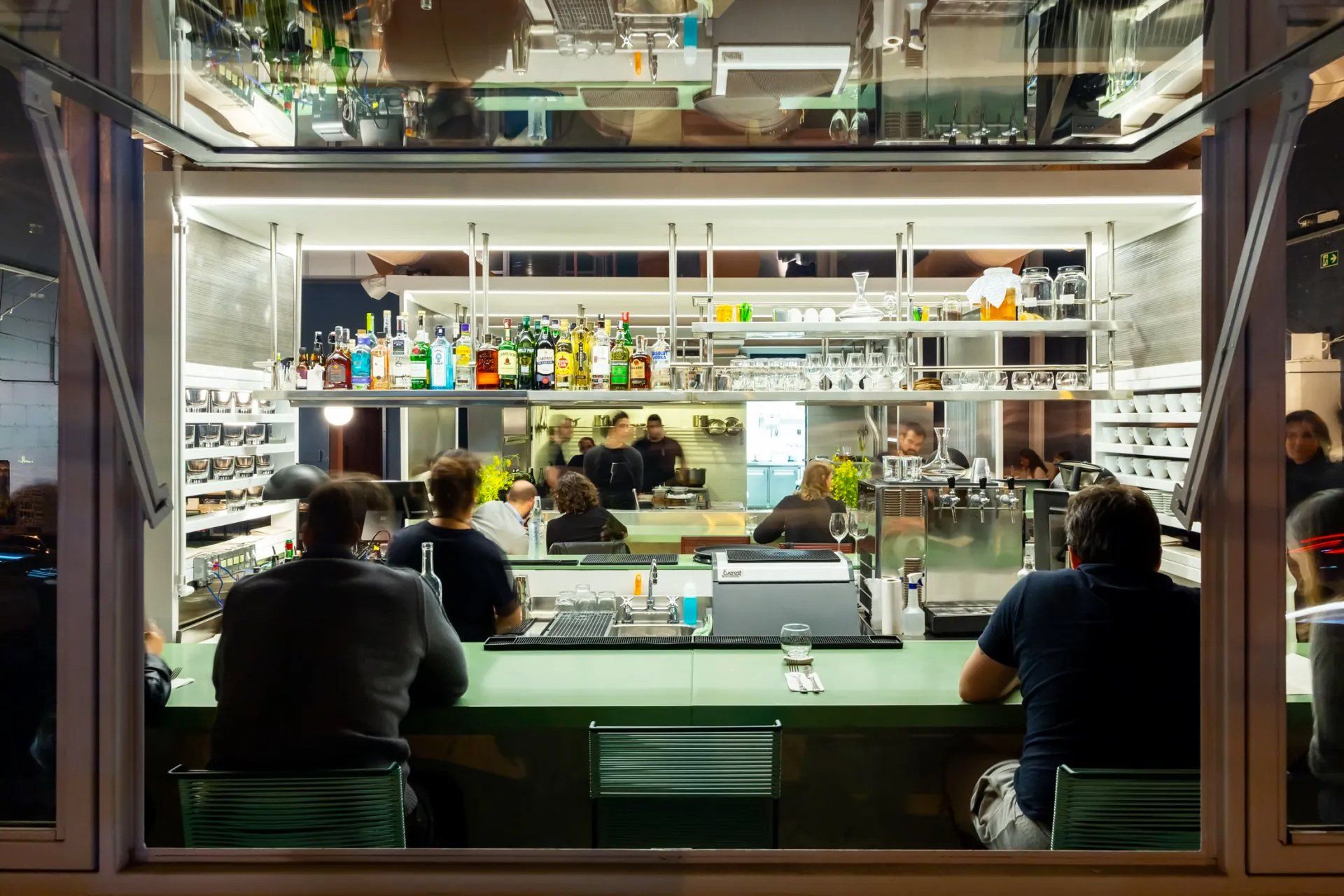 Um grupo de pessoas está sentado em um bar de um restaurante.