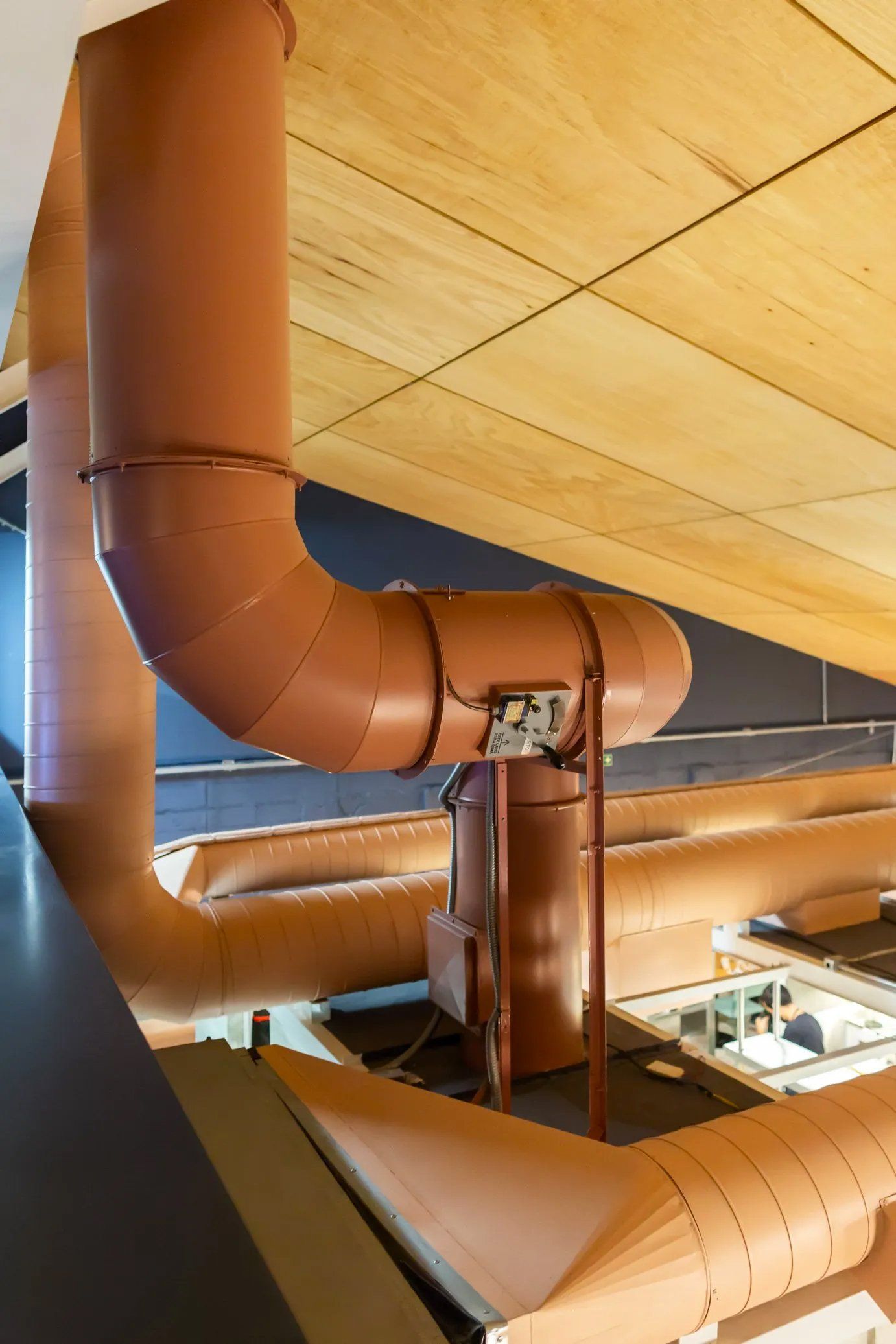 Um monte de canos está pendurado no teto de um prédio