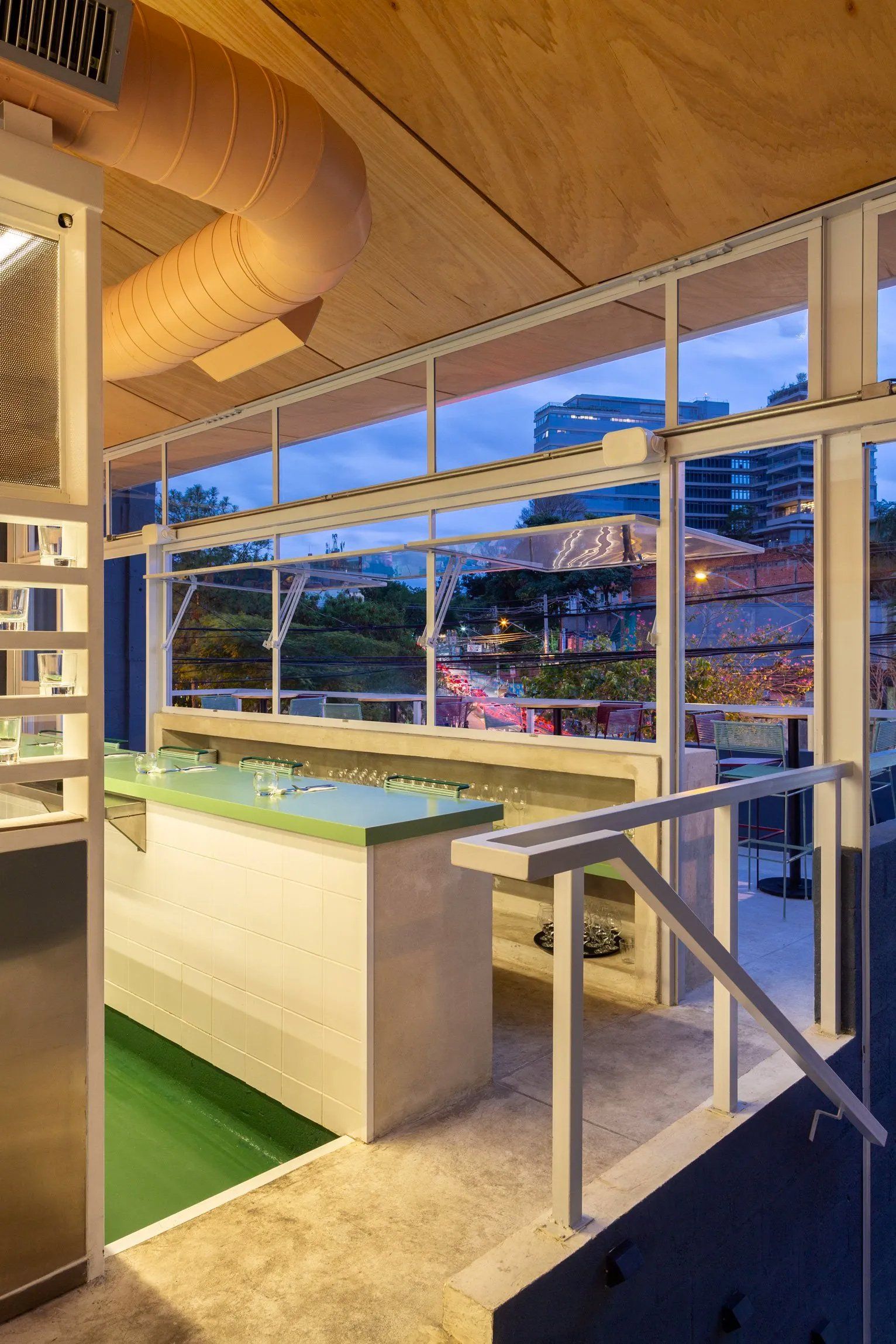 Uma sala grande com muitas janelas e uma mesa no meio.