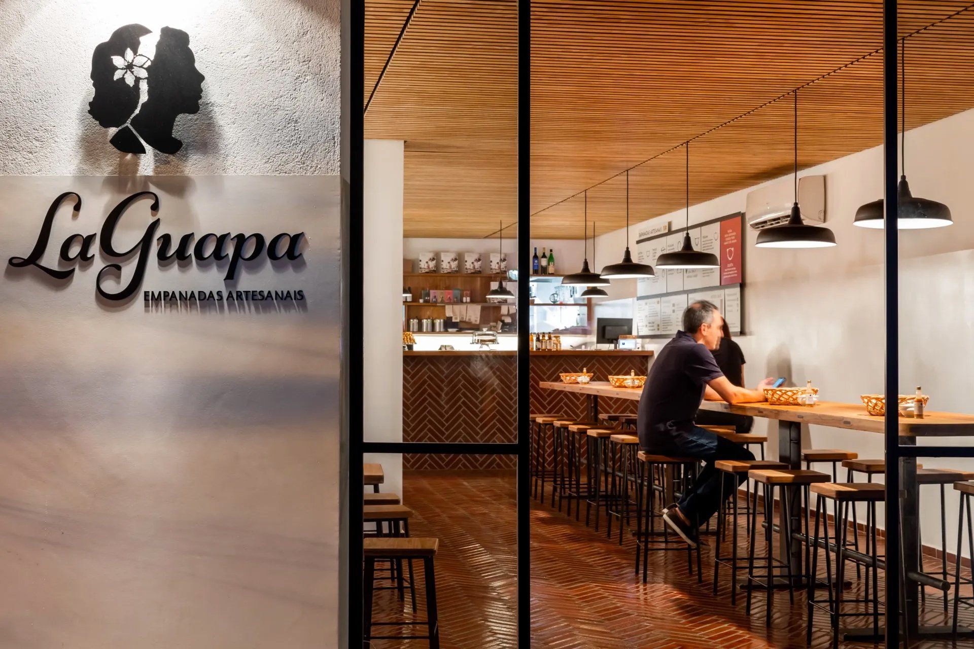 Um homem está sentado à mesa de um restaurante.