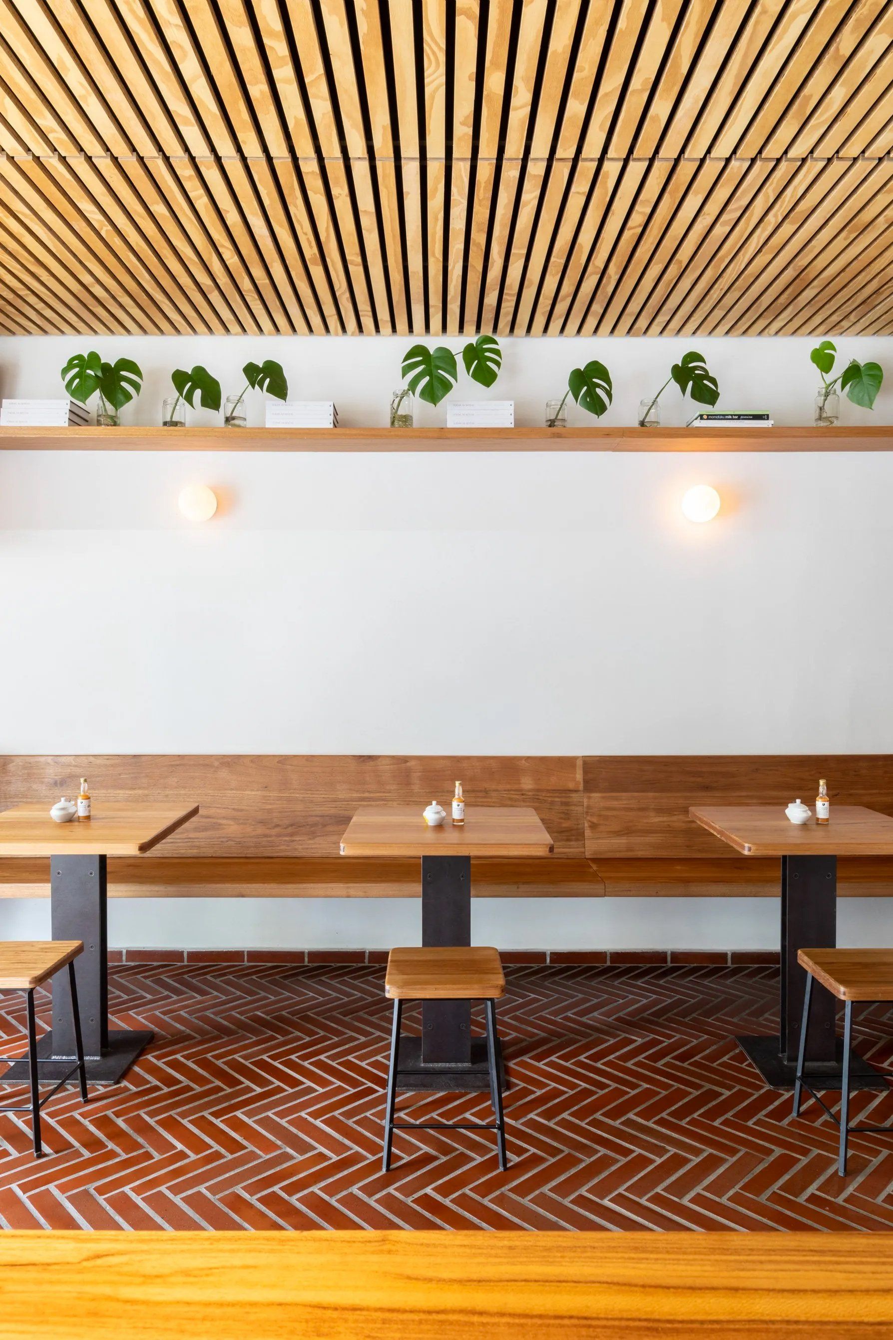 Um restaurante com mesas e cadeiras de madeira e teto de madeira.