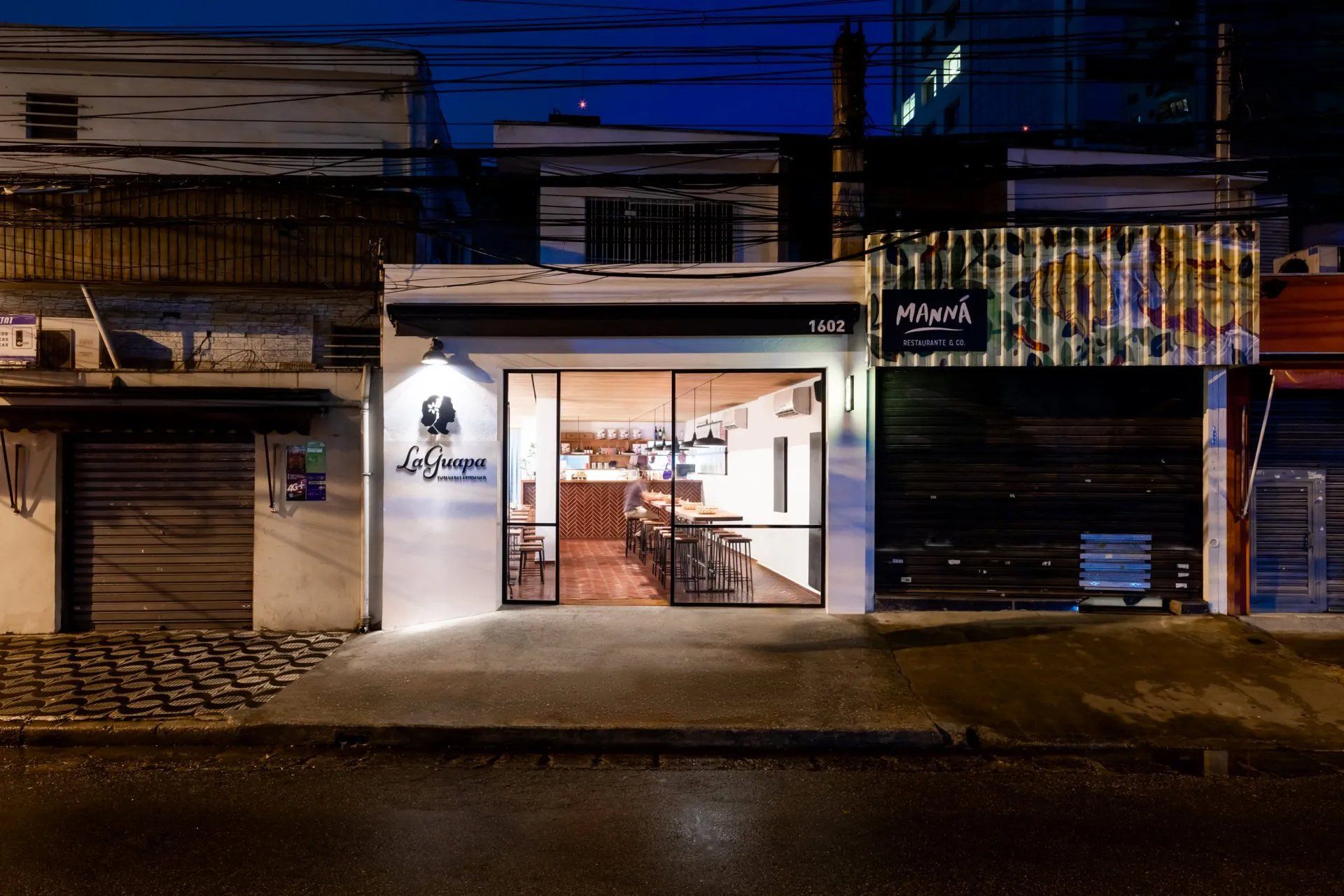 Um restaurante está localizado no meio de uma área residencial à noite.