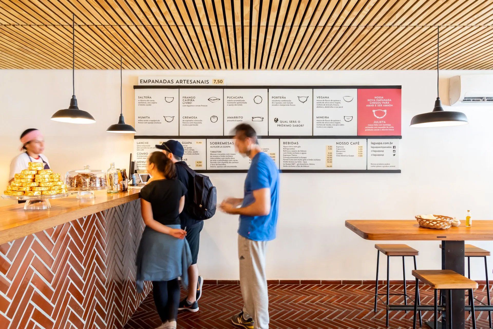 Um grupo de pessoas está em frente ao balcão de um restaurante.