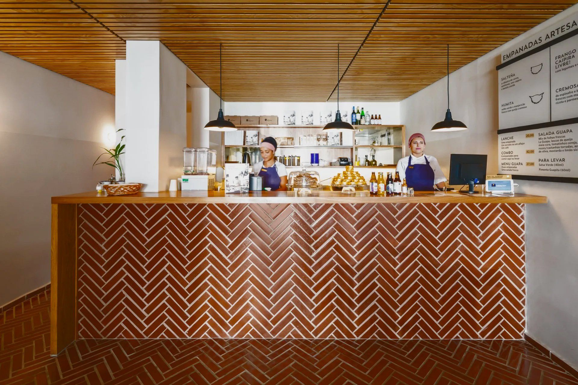 Algumas pessoas atrás de um balcão em um restaurante.