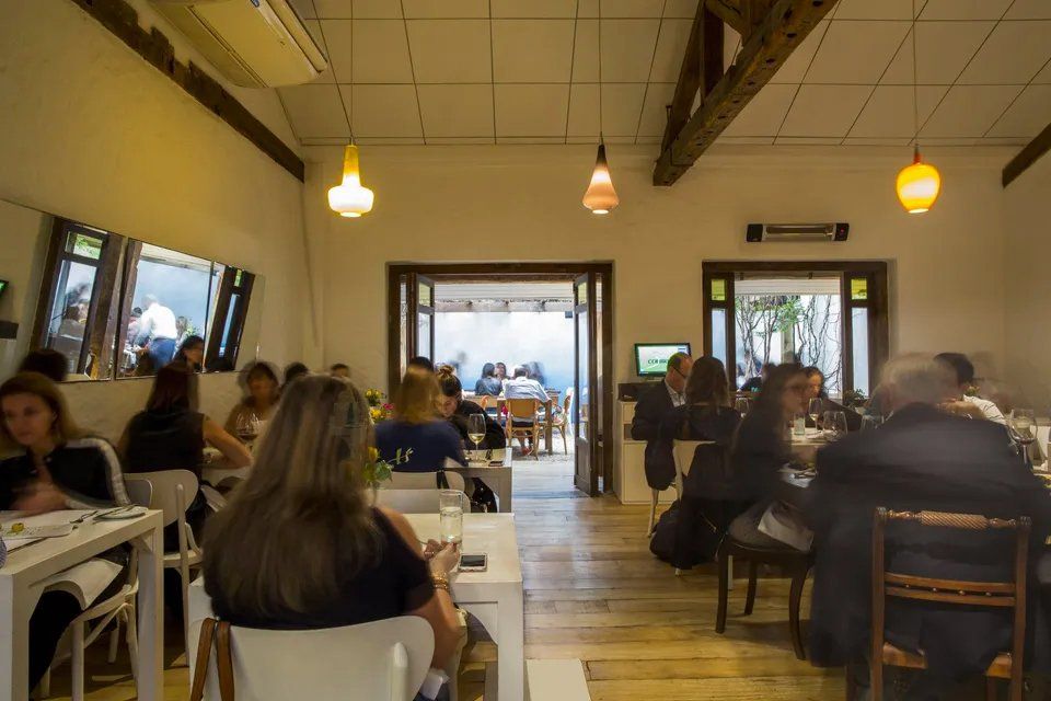 Um grupo de pessoas está sentado às mesas de um restaurante.