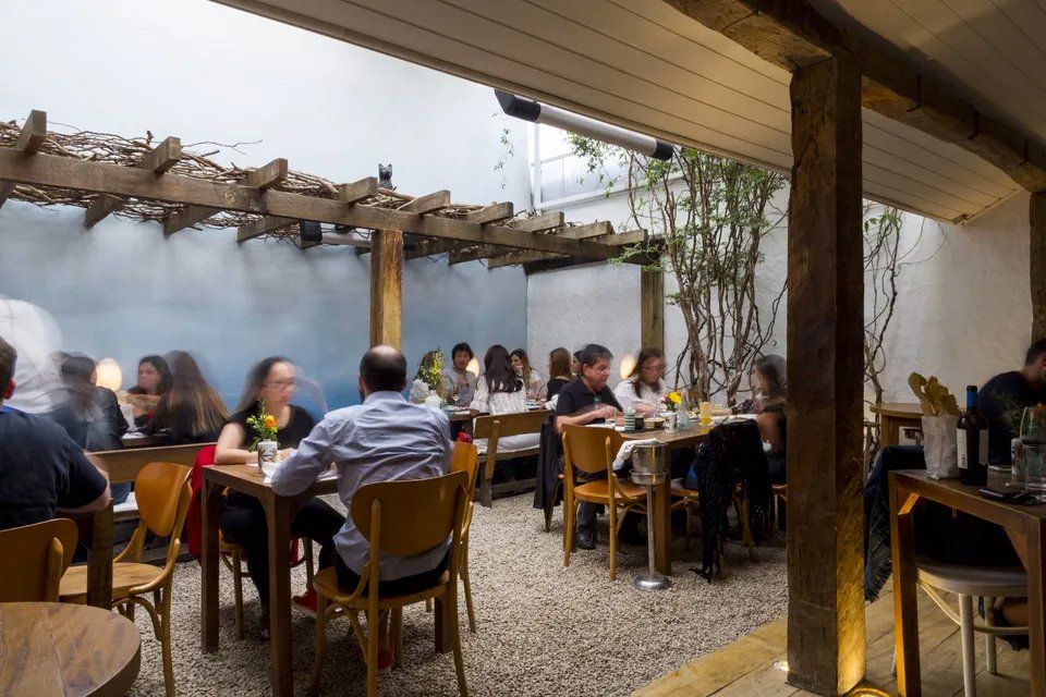 Um grupo de pessoas está sentado às mesas de um restaurante.