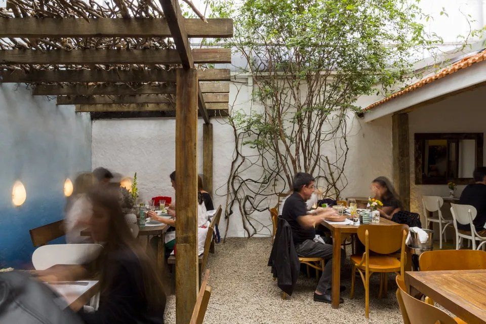 Um grupo de pessoas está sentado às mesas de um restaurante.