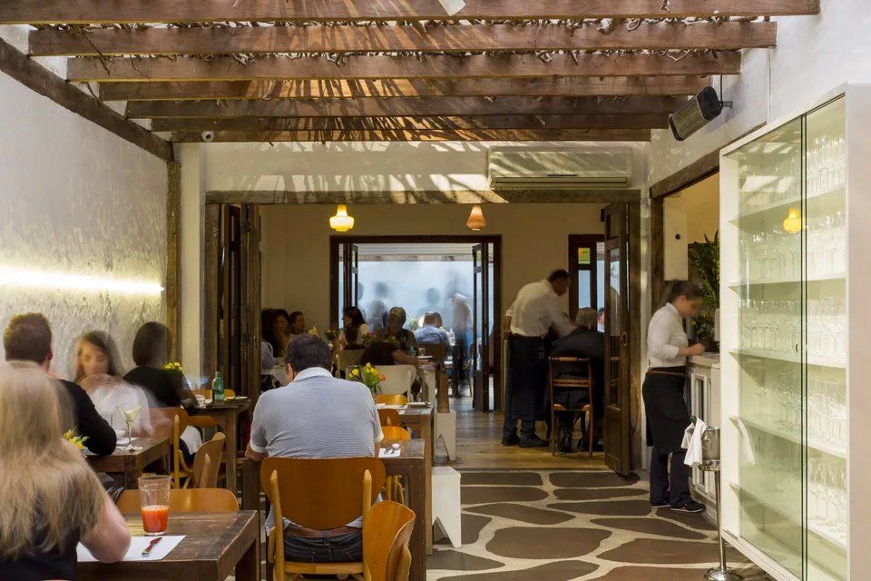 Um grupo de pessoas está sentado às mesas de um restaurante.