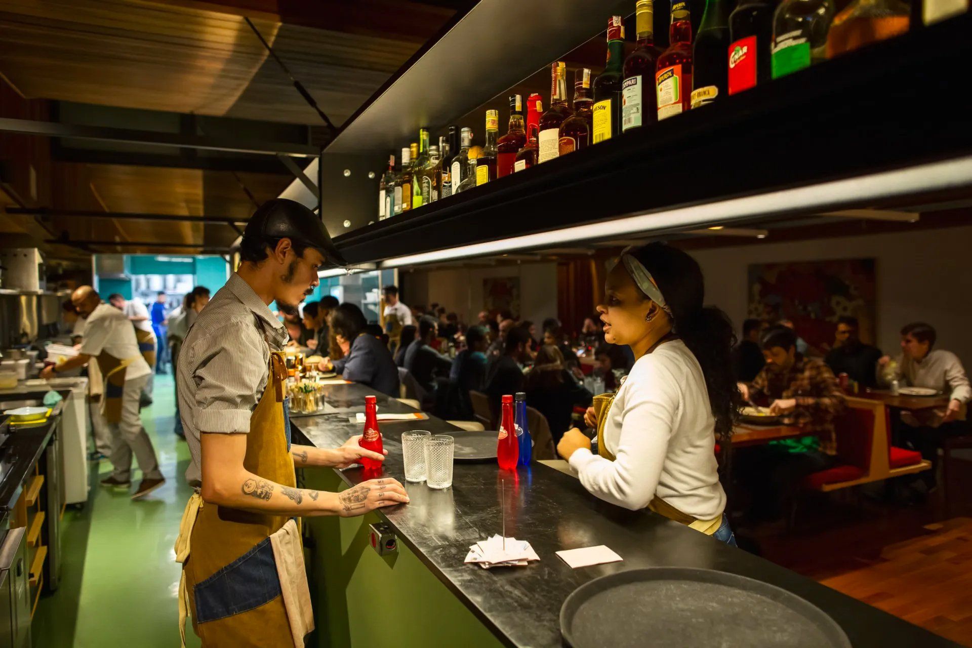 Um homem e uma mulher estão em um bar de um restaurante.