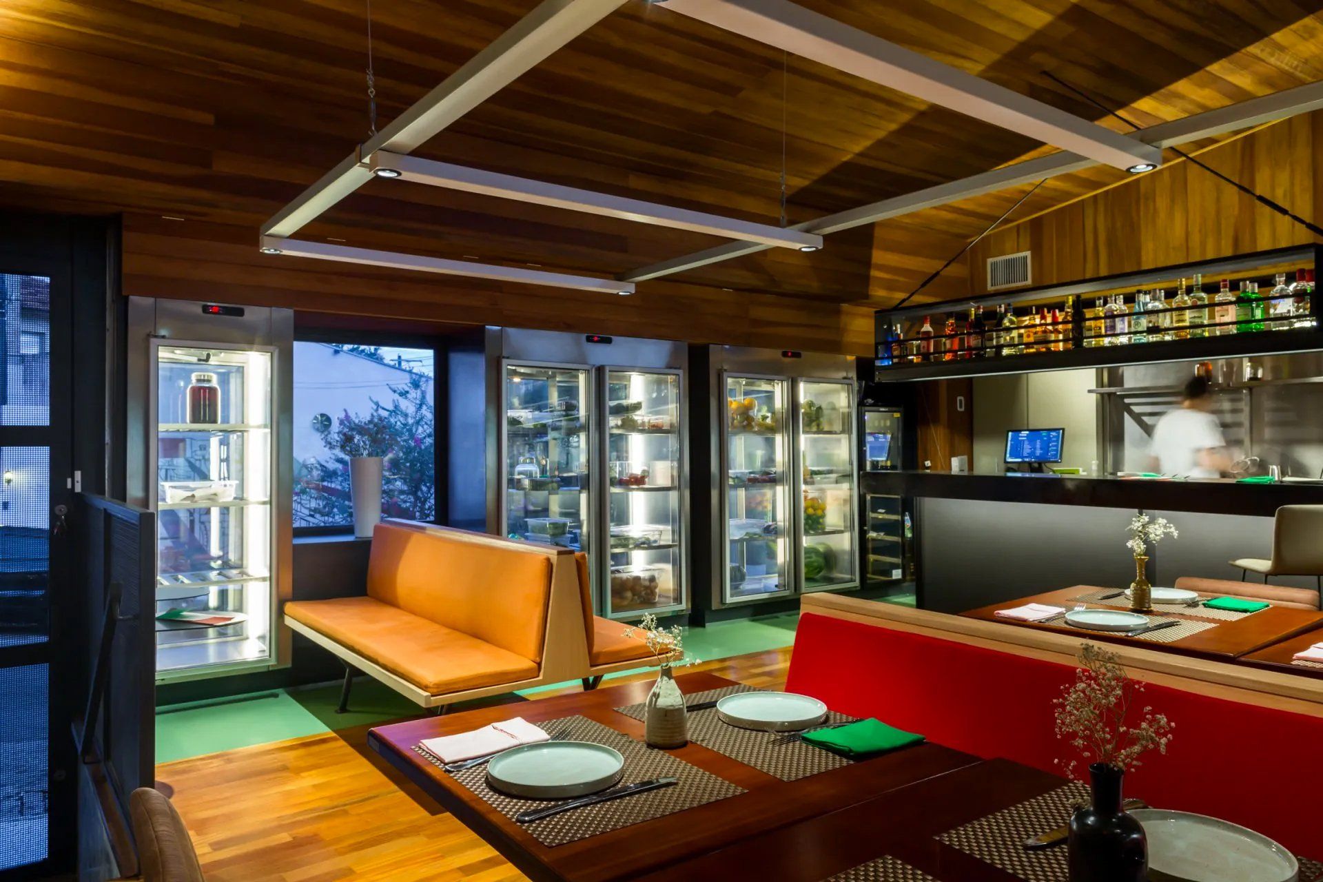 Um restaurante com mesas e cadeiras e um sofá.