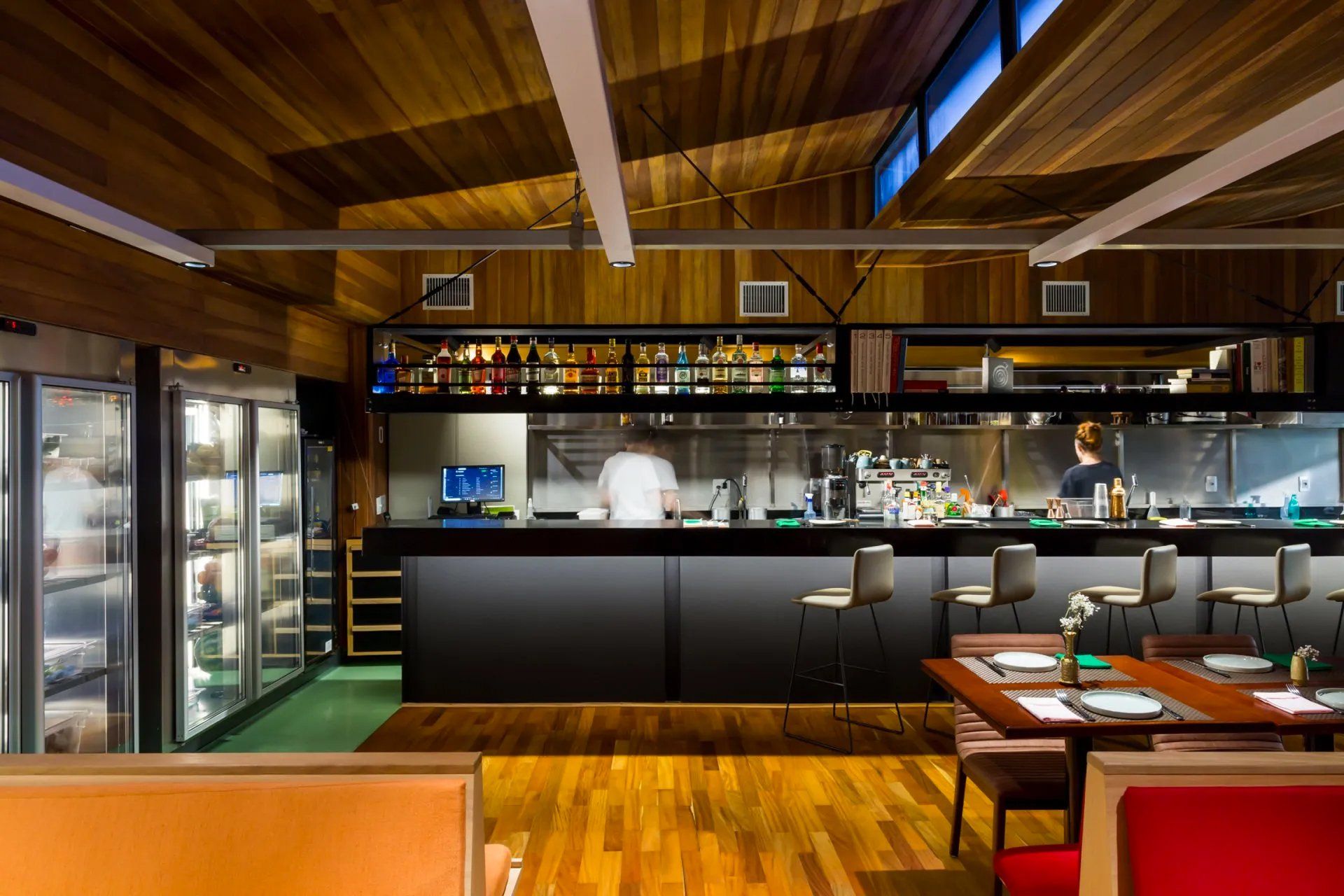 Um restaurante com mesas e cadeiras e um chef na cozinha