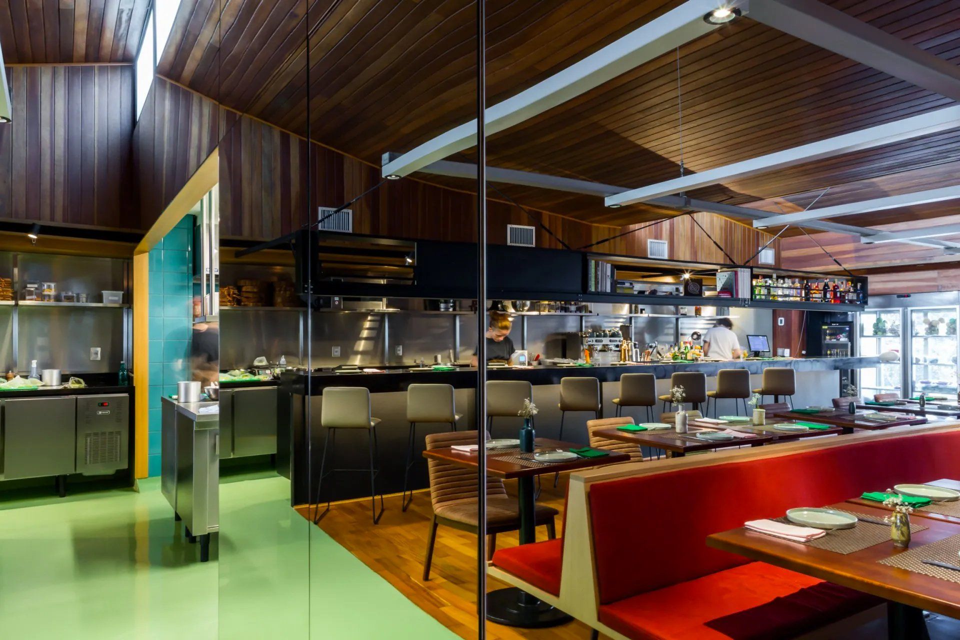 Um restaurante com mesas e cadeiras e uma cozinha ao fundo