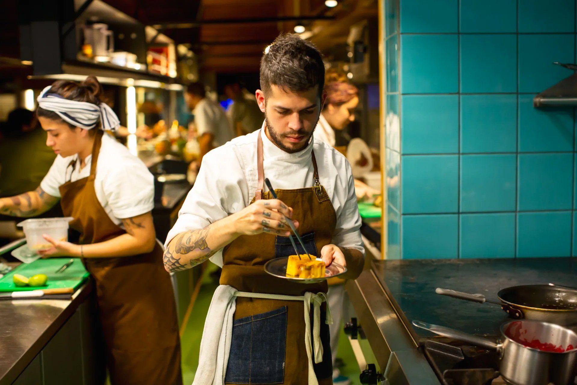 Um homem e uma mulher estão cozinhando comida em uma cozinha.