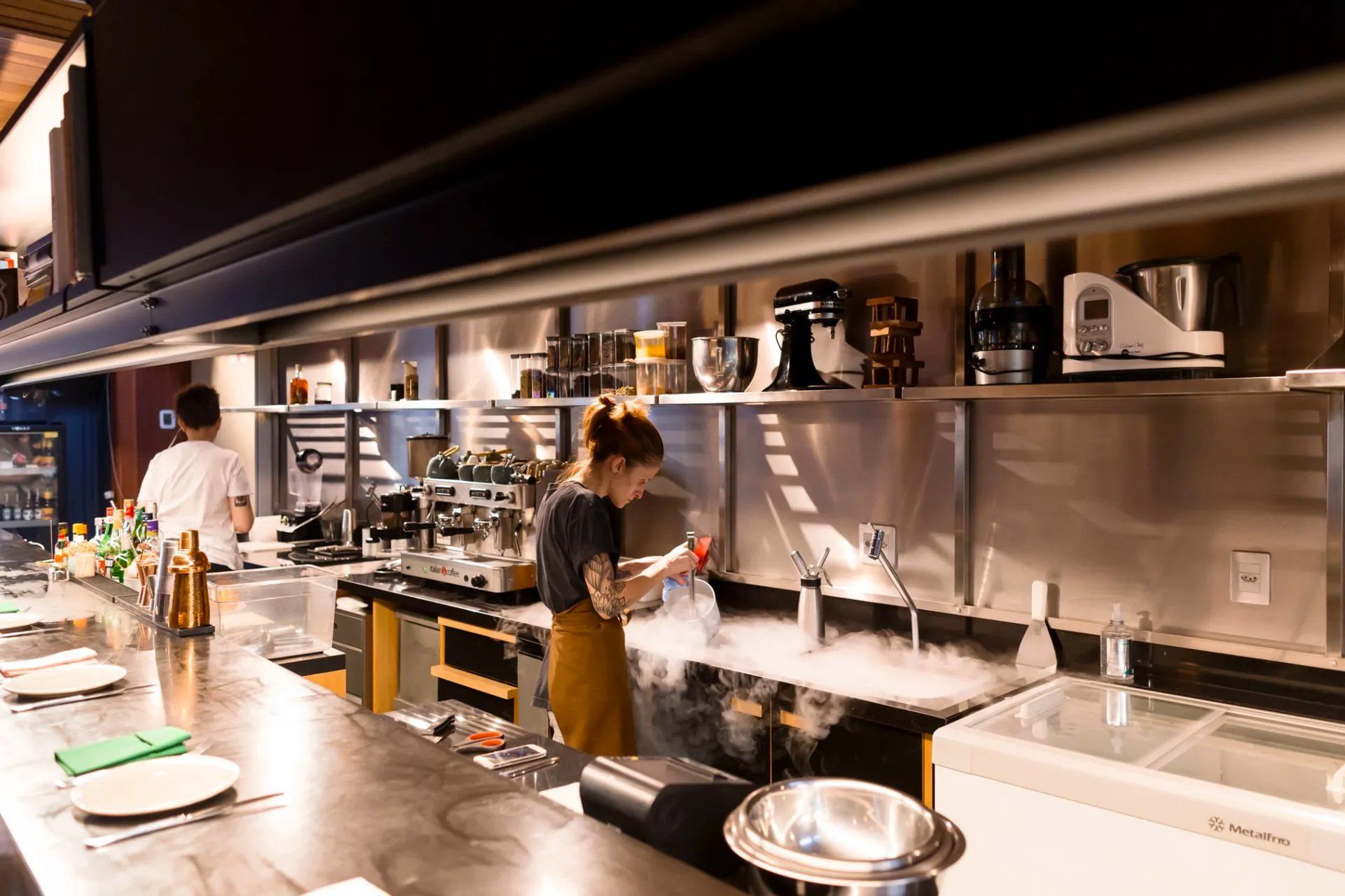 Uma mulher está em uma cozinha preparando comida.