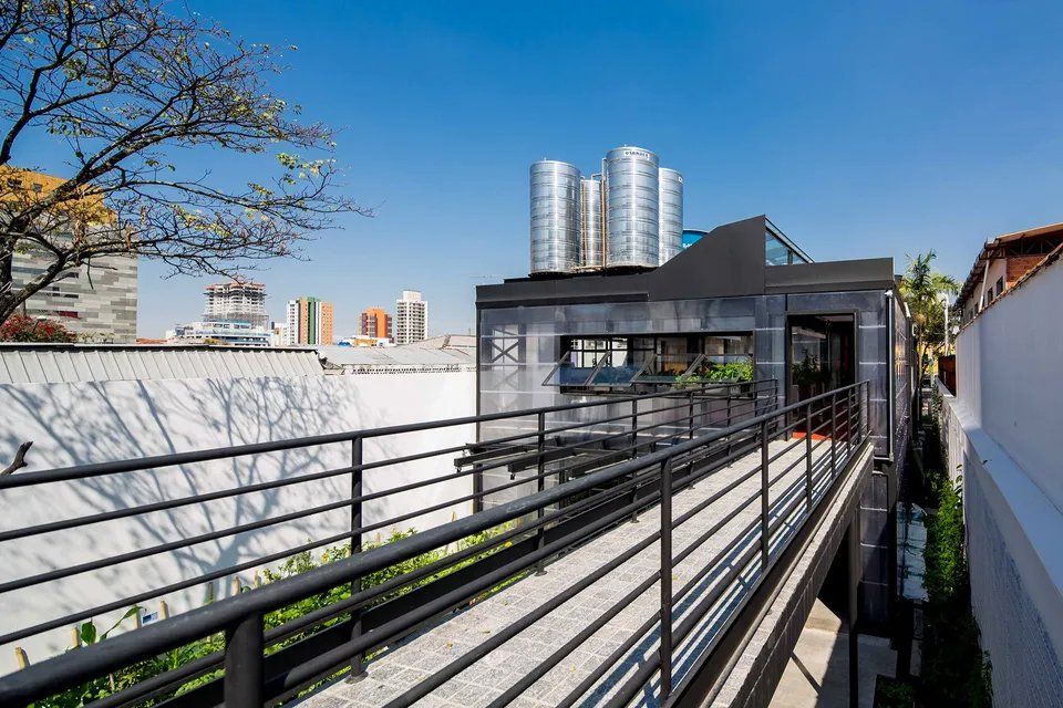 Uma ponte que leva a um prédio com uma cidade ao fundo.