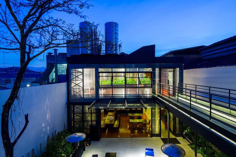 Um grande edifício com muitas janelas fica iluminado à noite.