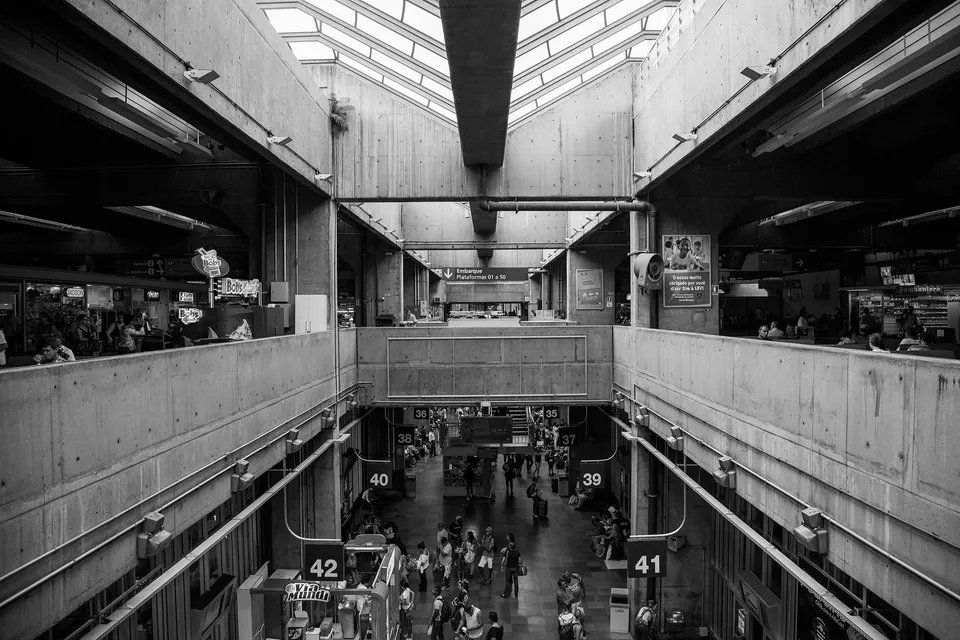 Uma foto em preto e branco de um grande edifício com pessoas andando por ele.