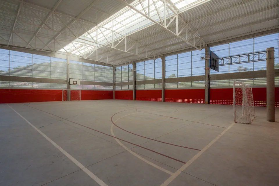 Uma grande quadra de basquete coberta com uma cesta de basquete e um gol.