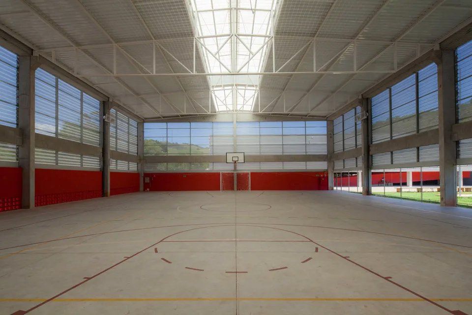 Uma grande quadra de basquete coberta com uma cesta de basquete no meio.