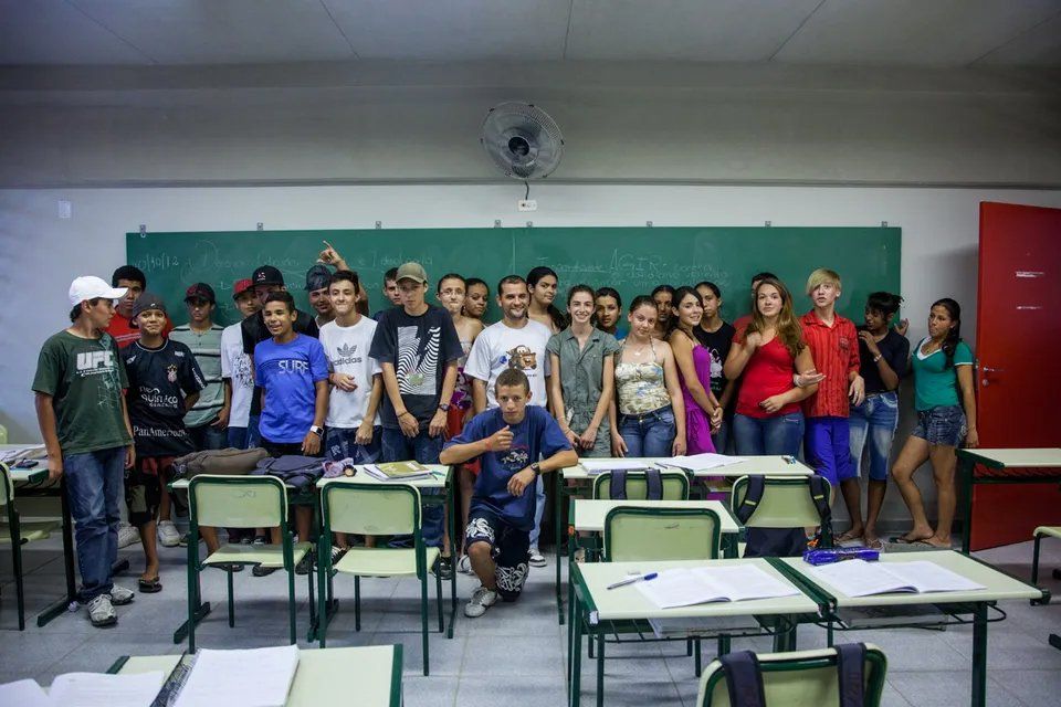 Um grupo de alunos posa para uma foto em uma sala de aula.