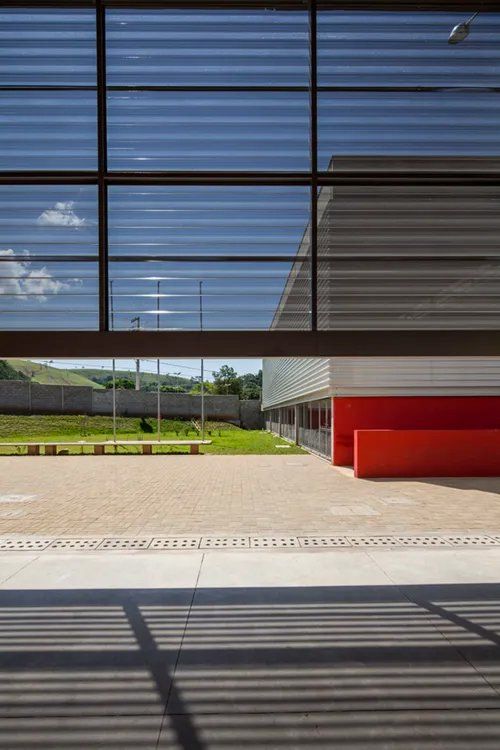 Um prédio com muitas janelas e um prédio vermelho ao fundo.