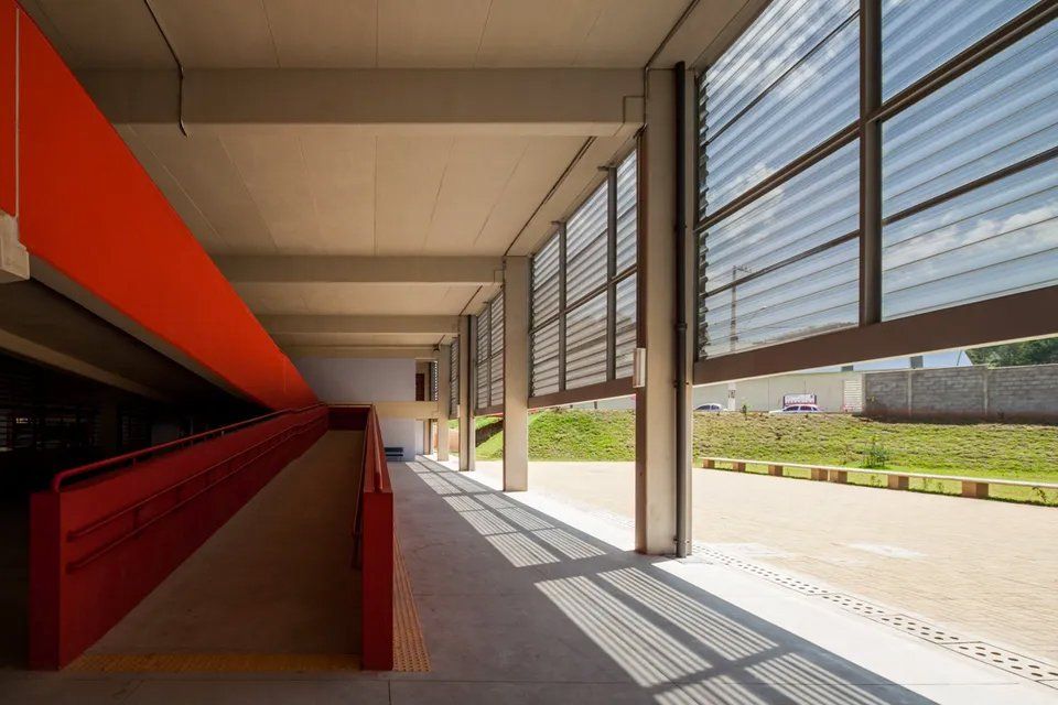 Um grande edifício com muitas janelas e uma rampa que leva até ele.