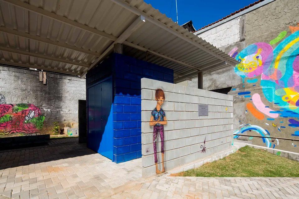 Uma pessoa está parada em frente a um prédio com pichações.