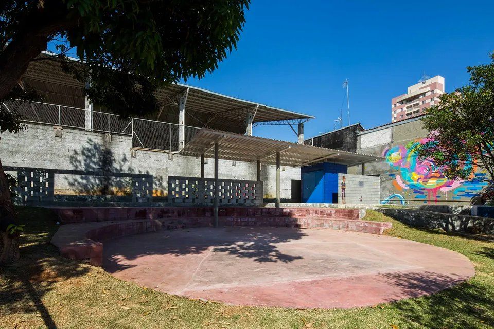 Há um grande edifício ao fundo com um mural na parede.