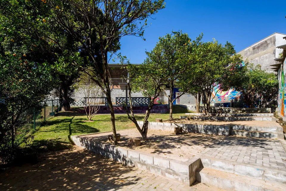 Um parque com árvores e um prédio ao fundo.